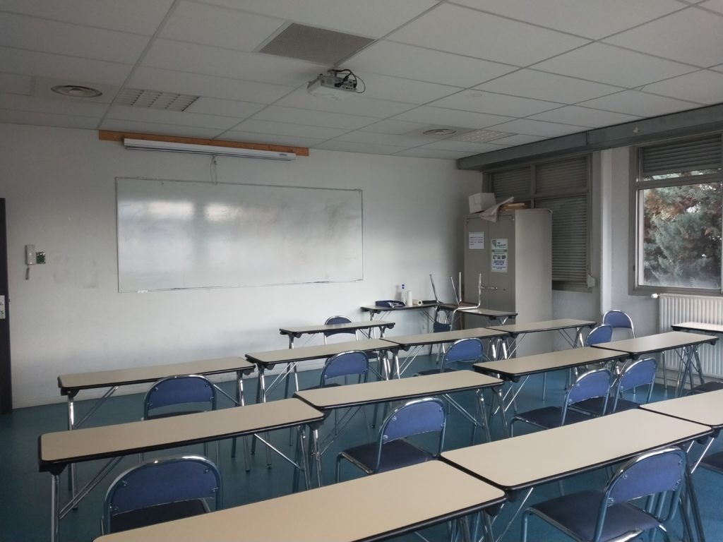 Salle de réunion avec des bureaux et des chaises