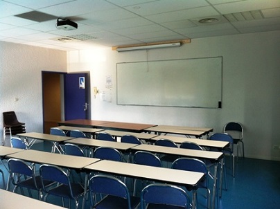 Salle de réunion disposé en ligne face à un tableau blanc