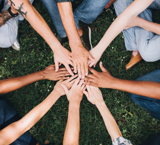 People stacking hands together in the park